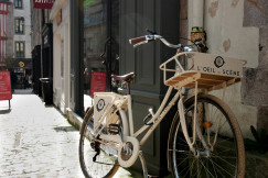 An illustrative photo of a brown city bike parked beside a building.