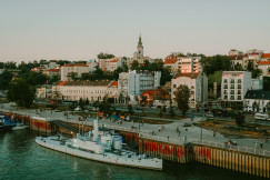 An illustrative photo of a harbor with boats and a city in the background.
