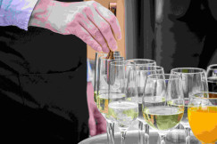 An illustrative photo of a person putting a piece of ice in a drink.