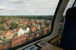An illustrative photo of a view on white and brown houses from the train window.