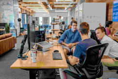 An illustrative photo of three men sitting in the office and having a discussion.
