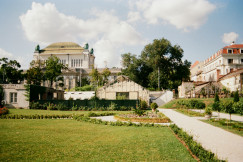 An illustrative photo of a grassy area with buildings in the background.