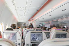 An illustrative photo of a man walking down the aisle of airplane.