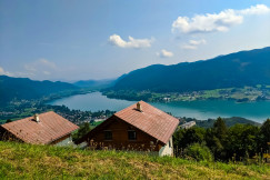 An illustrative photo of houses on a hill with a river in the background.
