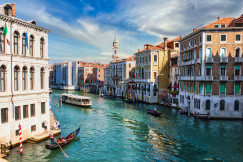 Photo by Unsplash An illustrative photo of boats on water between buildings.