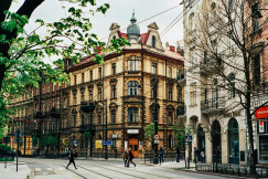 An illustrative photo of people walking near beige buildings.