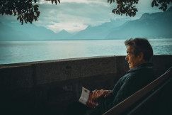 An illustrative photo of a man sitting while holding a book.