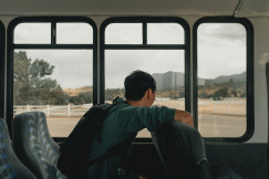 An illustrative photo of a man sitting inside a vehicle.