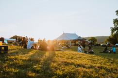 An illustrative photo of a group of people sitting on top of a field.
