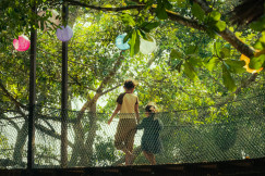 An illustrative photo of a woman and a child walking across a bridge.