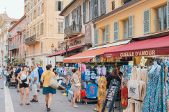 An illustrative photo of a group of people walking down a street next to shops