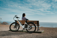 An illustrative photo of a man sitting on a brown wooden bench.