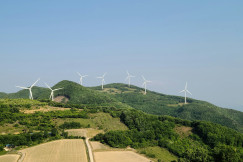 An illustrative photo of wind turbines on a hill.