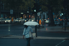 An illustrative photo of a man in gray jacket holding an umbrella.