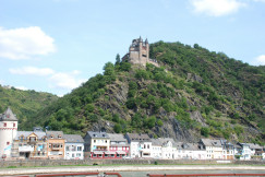 An illustrative photo of a castle on top of a mountain in a town.