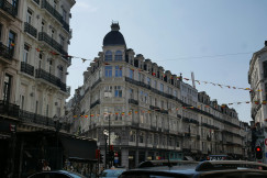 An illustrative photo of a city street filled with lots of cars between tall buildings.