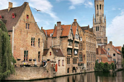 An illustrative photo of brown concrete buildings beside a river.