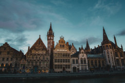 An illustrative photo of brown buildings near a river.