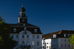 An illustrative photo of a large white building with a clock tower.