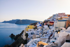 An illustrative photo of houses on a hill near a sea.