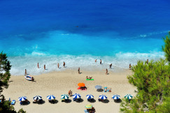 An illustrative photo of a group of people swimming on beach.