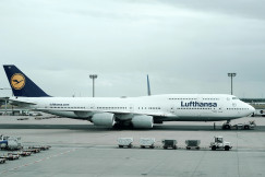 An illustrative photo of a blue and white parked airplane.
