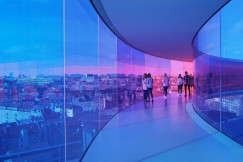 An illustrative photo of people walking in a glass tunnel. 
