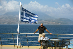 An illustrative photo of a man standing on a balcony.