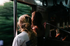An illustrative photo of two person standing on a train.