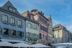 An illustrative photo of a row of buildings with umbrellas in front of them.