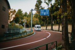 An illustrative photo of a white van driving down a curvy road.