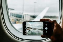 An illustrative photo of a phone capturing plane wing.