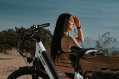 An illustrative photo of a woman sitting next to a bicycle.