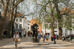 An illustrative photo of people standing around a statue.