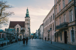 An illustrative photo of people walking on sidewalk near buildings.