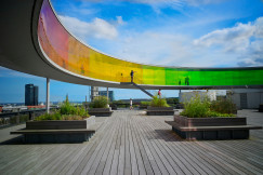 An illustrative photo of people walking on a multicoloured bridge.