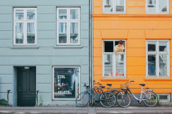 An illustrative photo of a person looking at bicycles from a window.