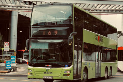 An illustrative photo of a green double decker bus driving down a street.