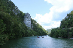 An illustrative photo of a body of water with boats and trees around it.