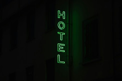An illustrative photo of a hotel sign lit up in the dark.