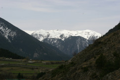 An illustrative photo of a valley with mountains in the background.