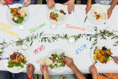 An illustrative photo of a group of people sitting around a table eating food.