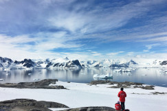 An illustrative photo of two people standing on a snow-covered coast.