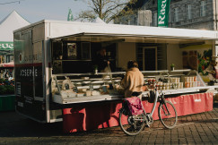 An illustrative photo of a woman buying something in a small shop.