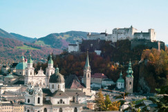 An illustrative photo of white buildings with mountains in the background.