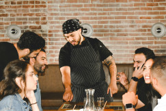 An illustrative photo of a waiter serving people in a restaurant.
