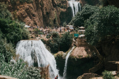 An illustrative photo of people on a hill beside waterfalls.