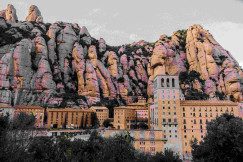 An illustrative photo of a large building with a large rock formation behind it.