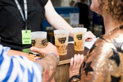 An illustrative photo of three filled Reuse Me cups on brown table.