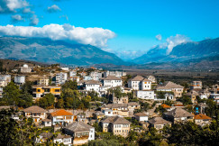 An illustrative photo of a view of a city with mountains in the background.